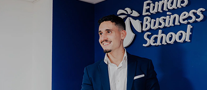 Homme souriant en costume devant le logo Euridis Business School