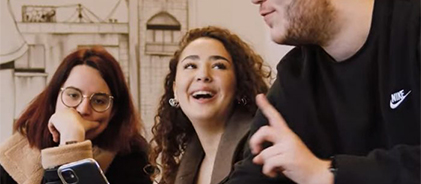 Trois étudiants riant ensemble dans un café