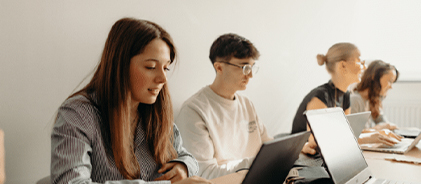 Étudiants concentrés sur leurs ordinateurs portables dans une salle lumineuse