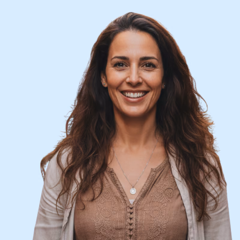Portrait de Manelle I., femme aux longs cheveux bruns bouclés, souriante
