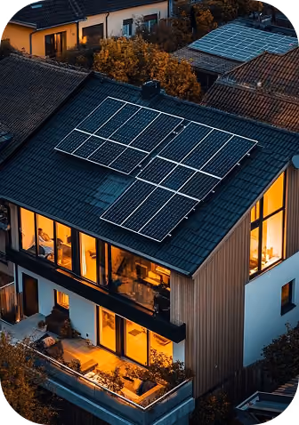 Modern house with solar panels on the roof and warm interior lights in the evening.
