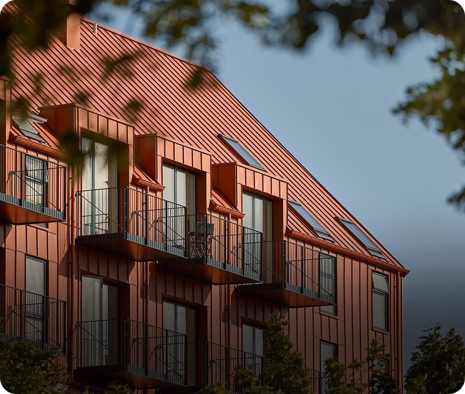 Mehrfamilienhaus mit rotem Metalldach und Balkonen – Schritt Modellprüfung