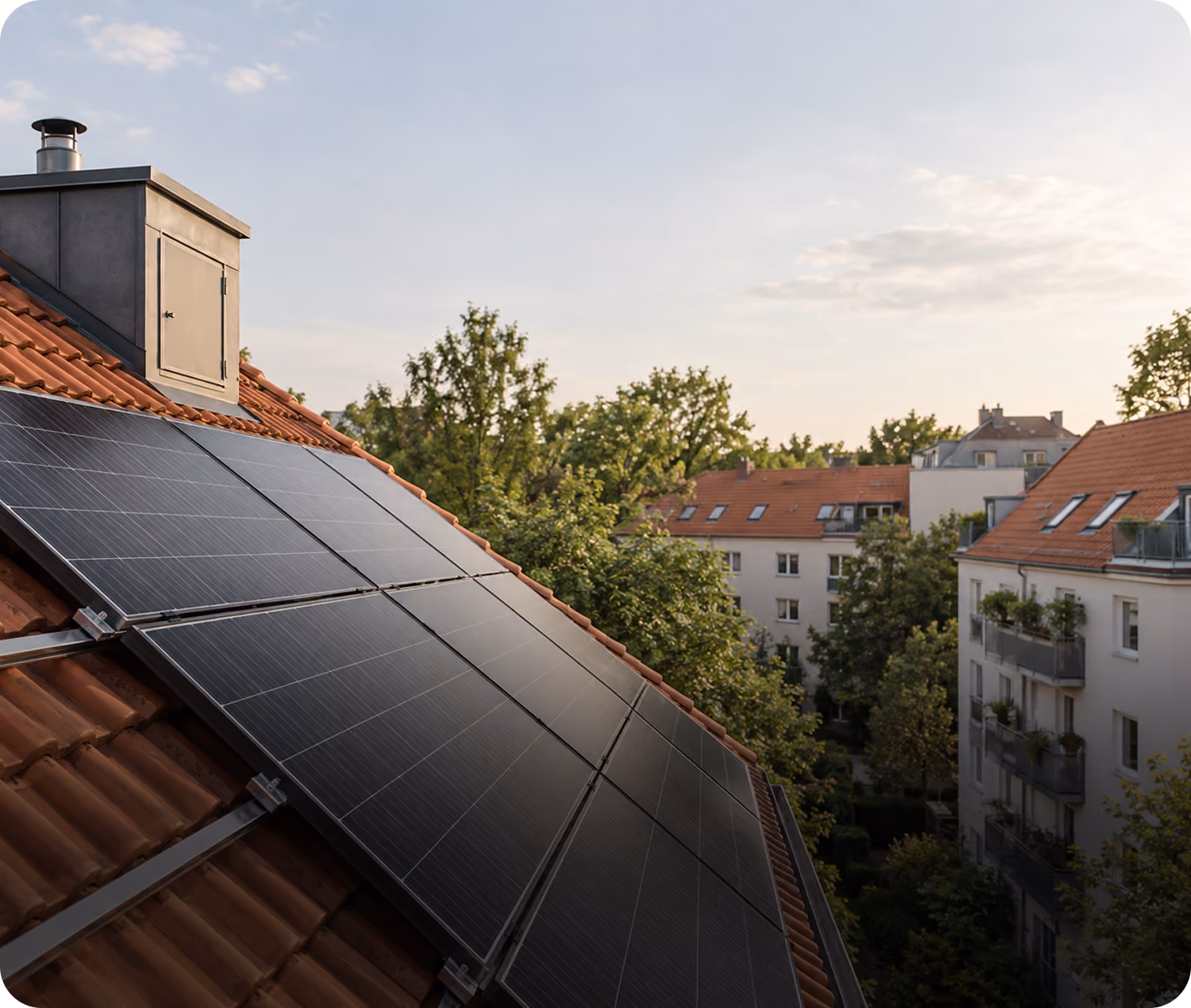 Solarmodule auf einem Ziegeldach mit Blick auf benachbarte Mehrfamilienhäuser