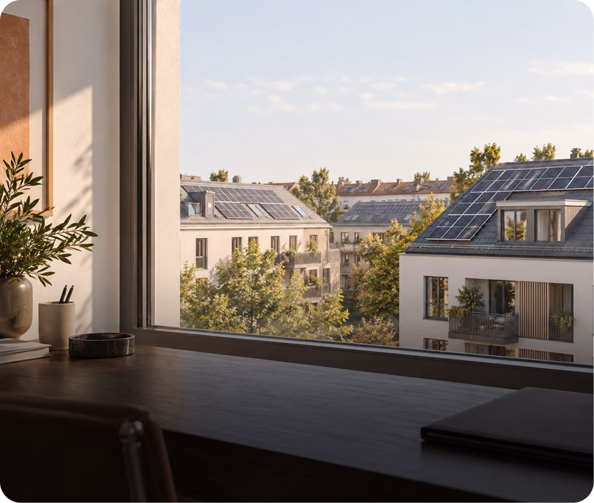 Blick aus dem Bürofenster auf Wohngebäude mit Solaranlagen auf den Dächern