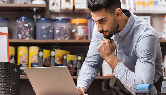 ecommerce manager reviewing product listings on laptop in retail environment