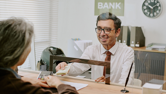 Bank employee assisting a customer at a branch service counter