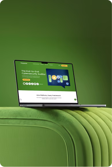 Laptop displaying a green-themed cybersecurity auditor platform screen, placed on a green textured surface.