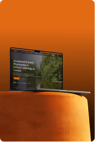 Laptop on an orange round pouf showing a website for exceptional summer programs in Oxford, Cambridge, and London.