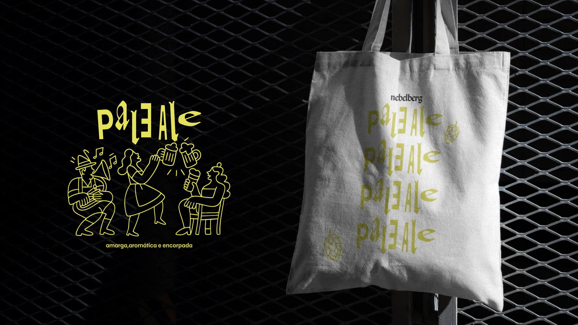 White tote bag with yellow stylized text and hop illustrations hanging against a dark metal grid backdrop.