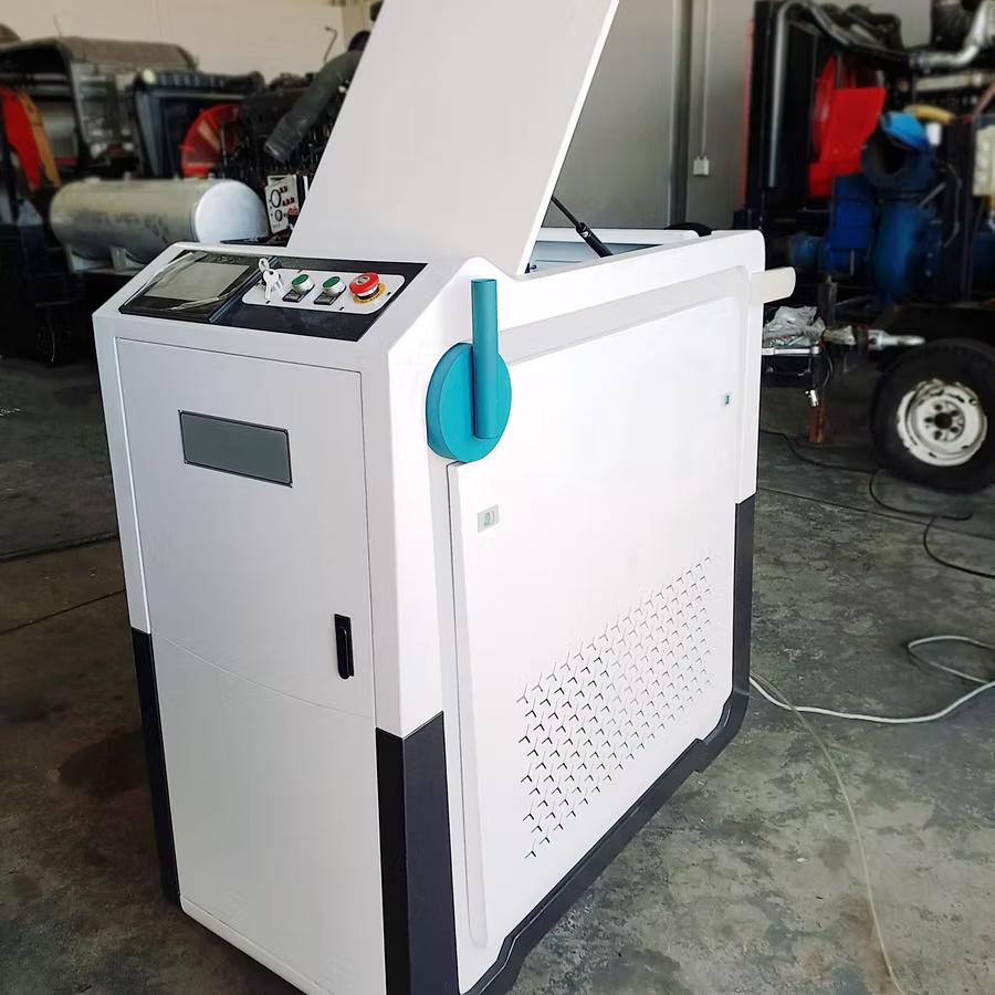 White industrial machine with a control panel and open top lid, placed on a concrete floor indoors.