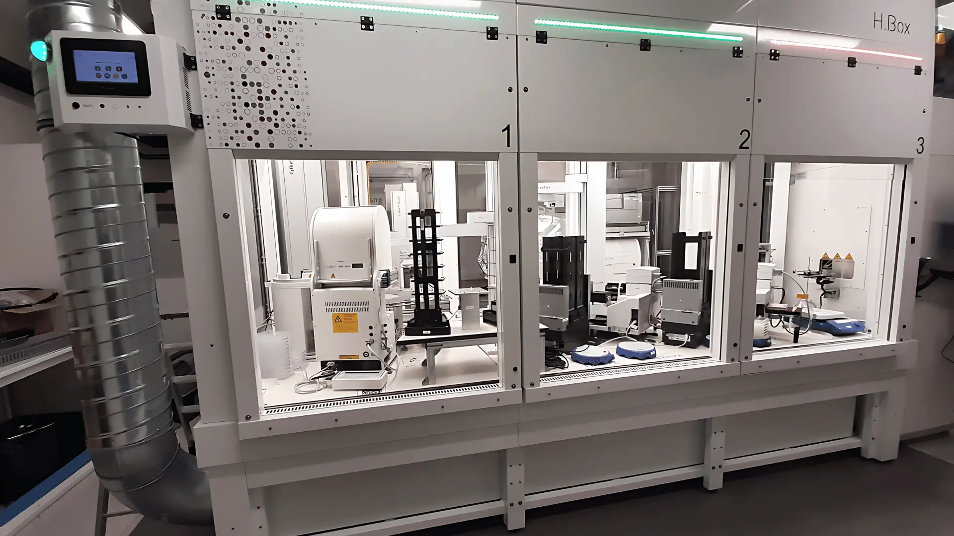 Plateforme robotique automatisée divisée en trois compartiments numérotés 1 à 3, équipée de divers instruments de laboratoire blancs et noirs pour des analyses scientifiques.