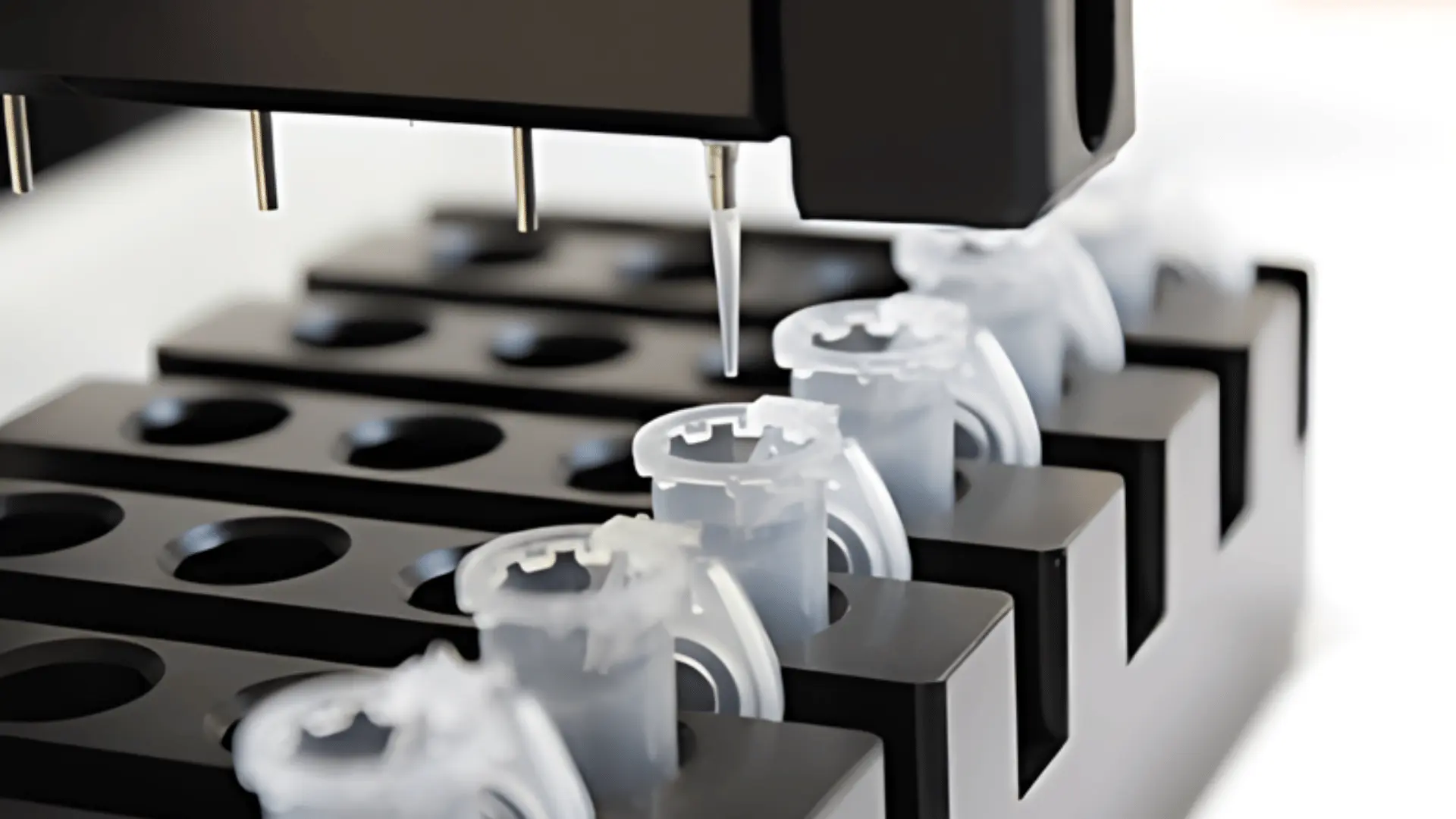 Distributeur automatique de réactifs à haut débit vers des microtubes transparents disposés sur un support noir en laboratoire.