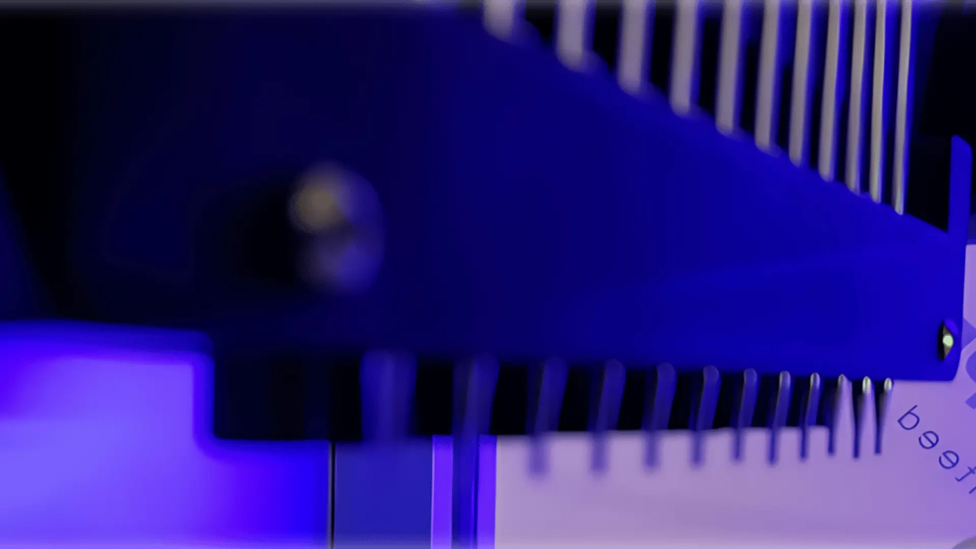 Gros plan d'un composant électronique bleu avec des broches ou connecteurs métalliques alignés, éclairé par une lumière violette.