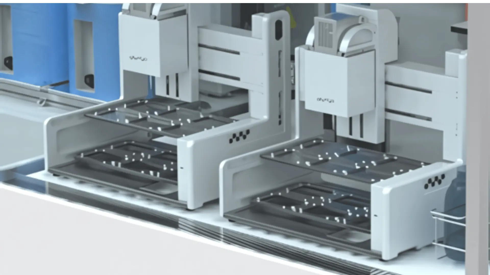Vue rapprochée d'un équipement de laboratoire automatisé avec des plateaux modulaires et plusieurs compartiments disposés en alignement.