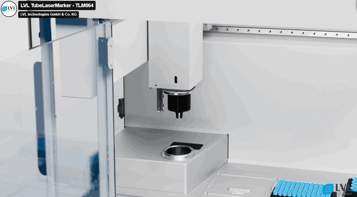 Machine laser industrielle LVL TubeLaserMarker TLM864, utilisée pour le marquage précis, avec un système de guidage et un compartiment pour les échantillons cylindriques bleus.