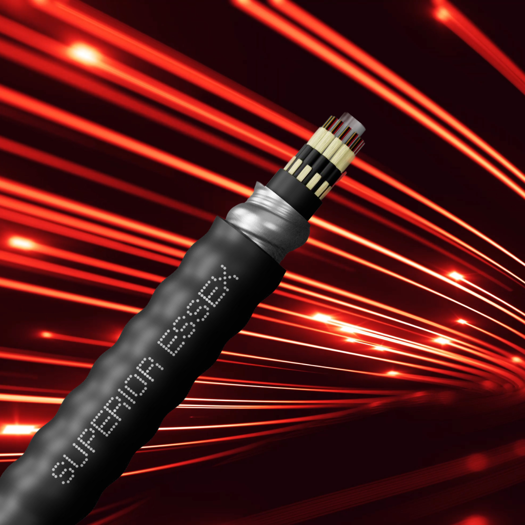 Close-up of a thick black fiber optic cable with the text 'SUPERIOR ESSEX' on its outer sheath and multiple fiber strands visible at the cut end, set against a dark background with red light trails resembling fast data transmission.