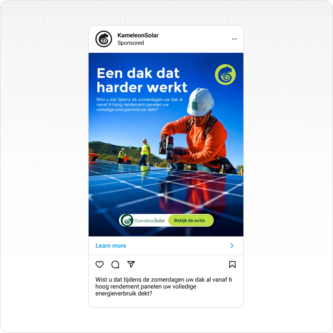 Worker in helmet and orange jacket installing solar panels on a roof under clear blue sky.