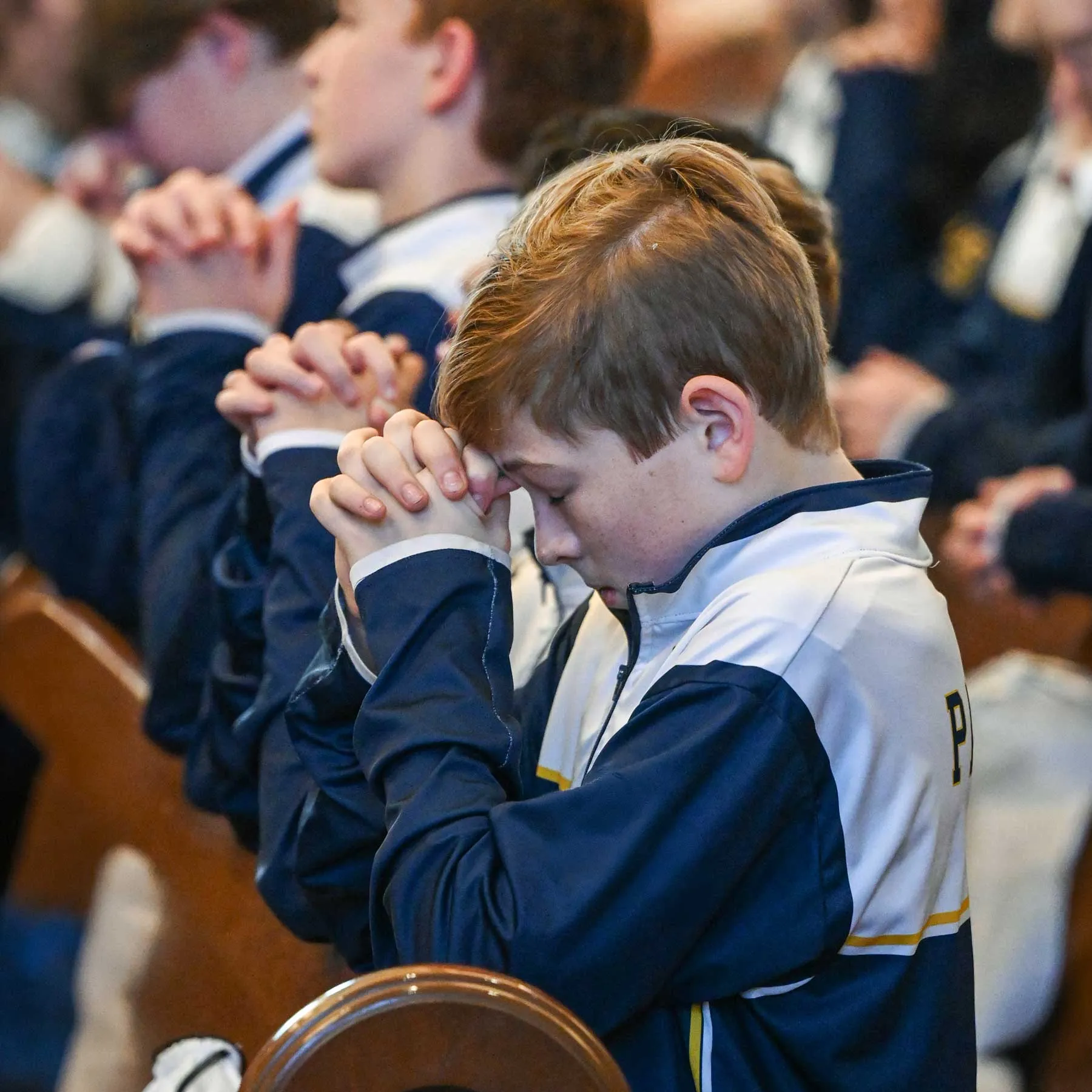 Catholic school student praying in church