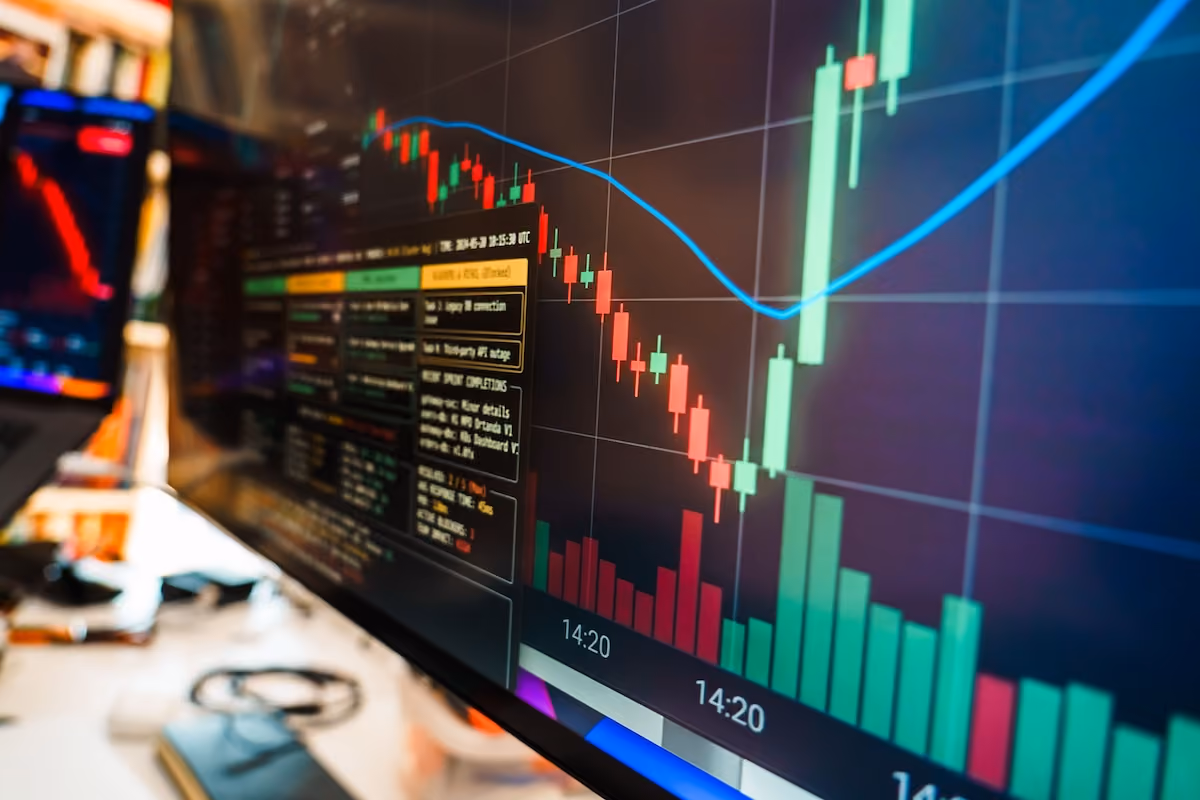 Close-up of a financial monitor displaying real-time cryptocurrency data and charts in a modern office.