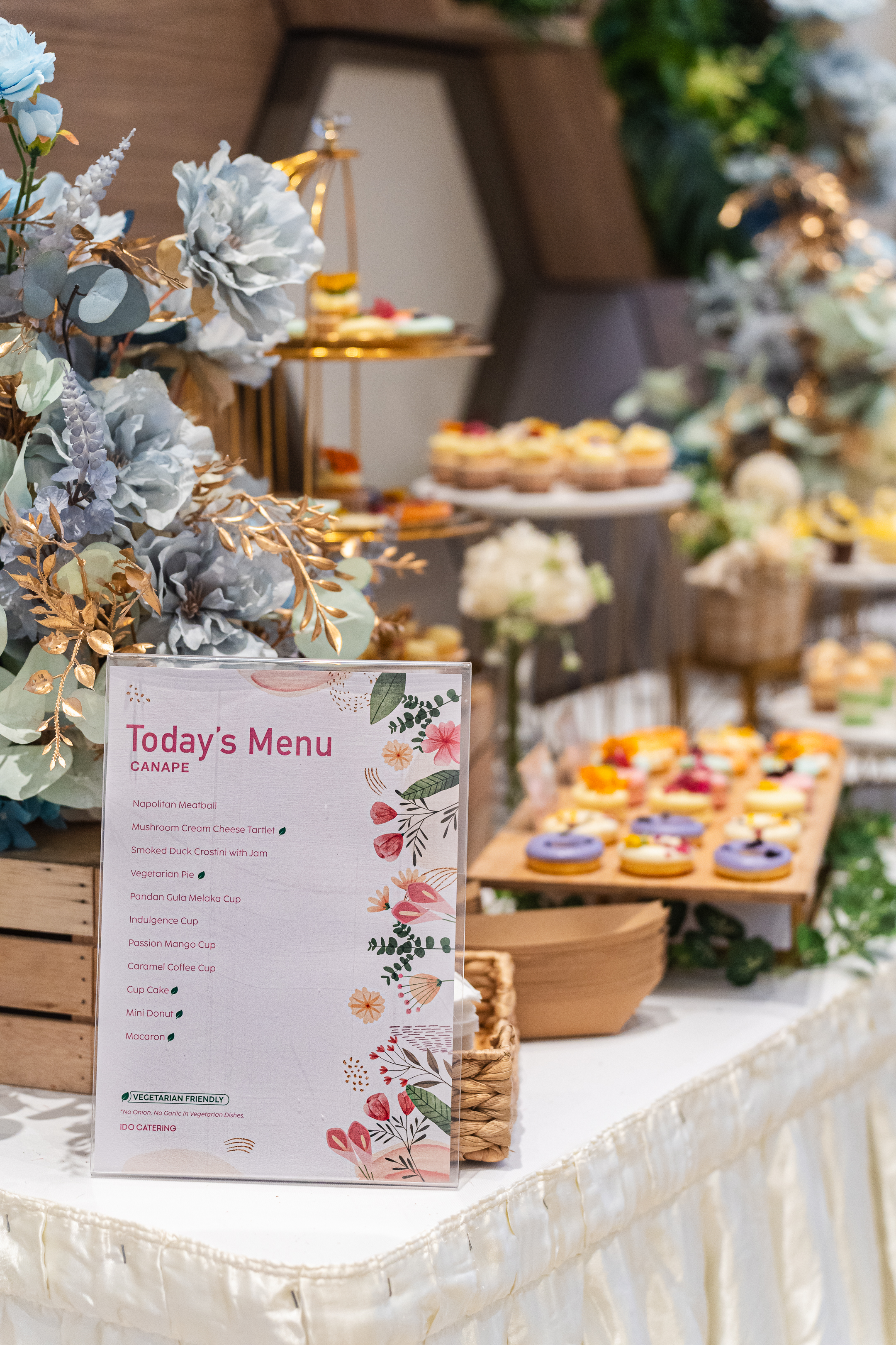 Dessert table styled with florals and a printed menu card
