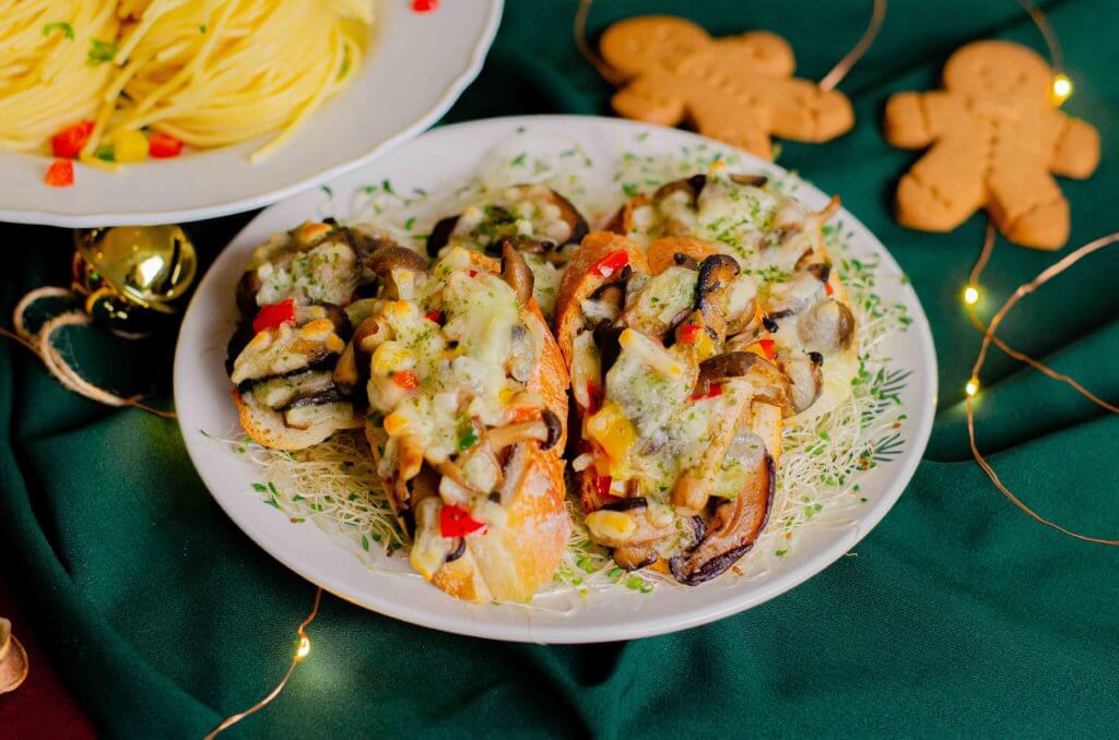Baked mushroom and cheese crostini beside gingerbread men, iDoCatering Christmas 2021 menu