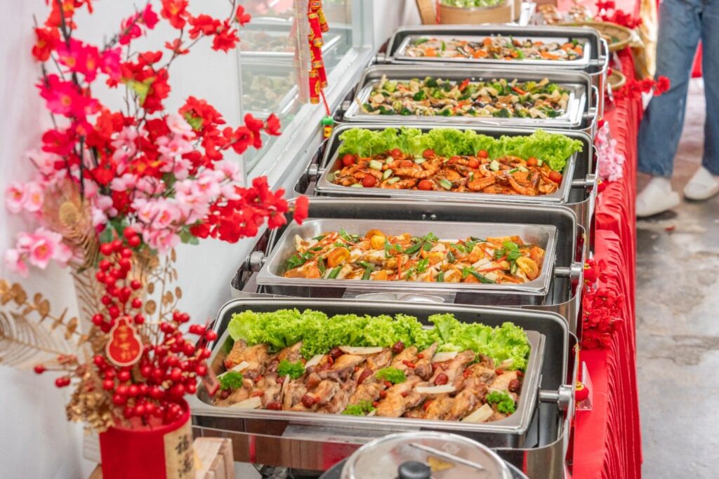 Chafing dish buffet line with chicken, prawns and vegetables at an iDoCatering Chinese New Year 2026 event