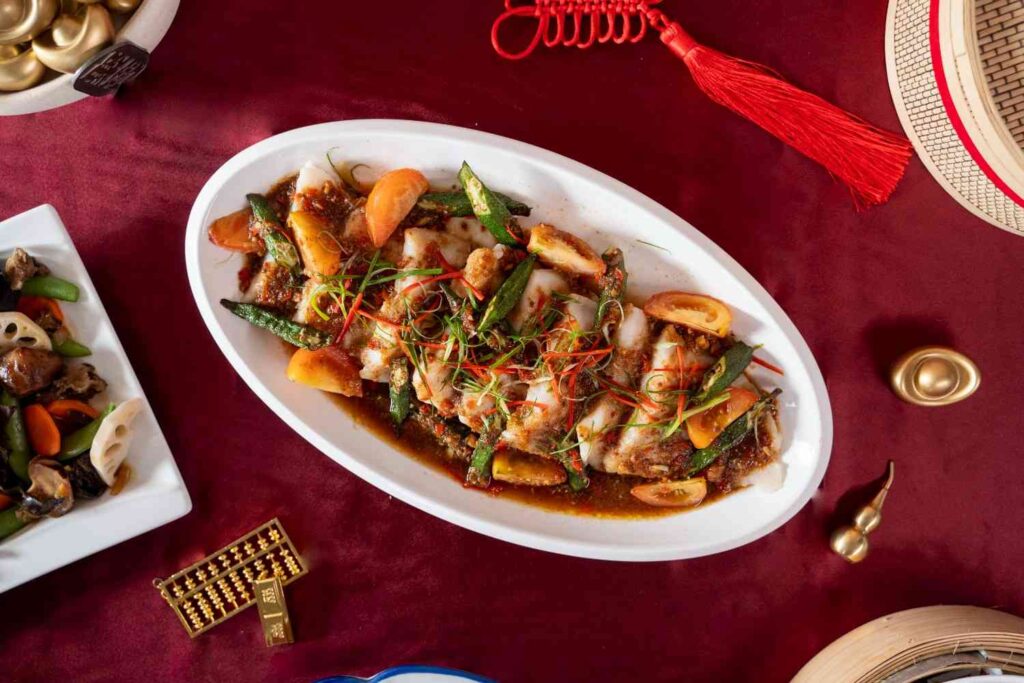 Steamed fish with okra, tomato and chilli on an oval platter, Chinese New Year 2026 catering menu