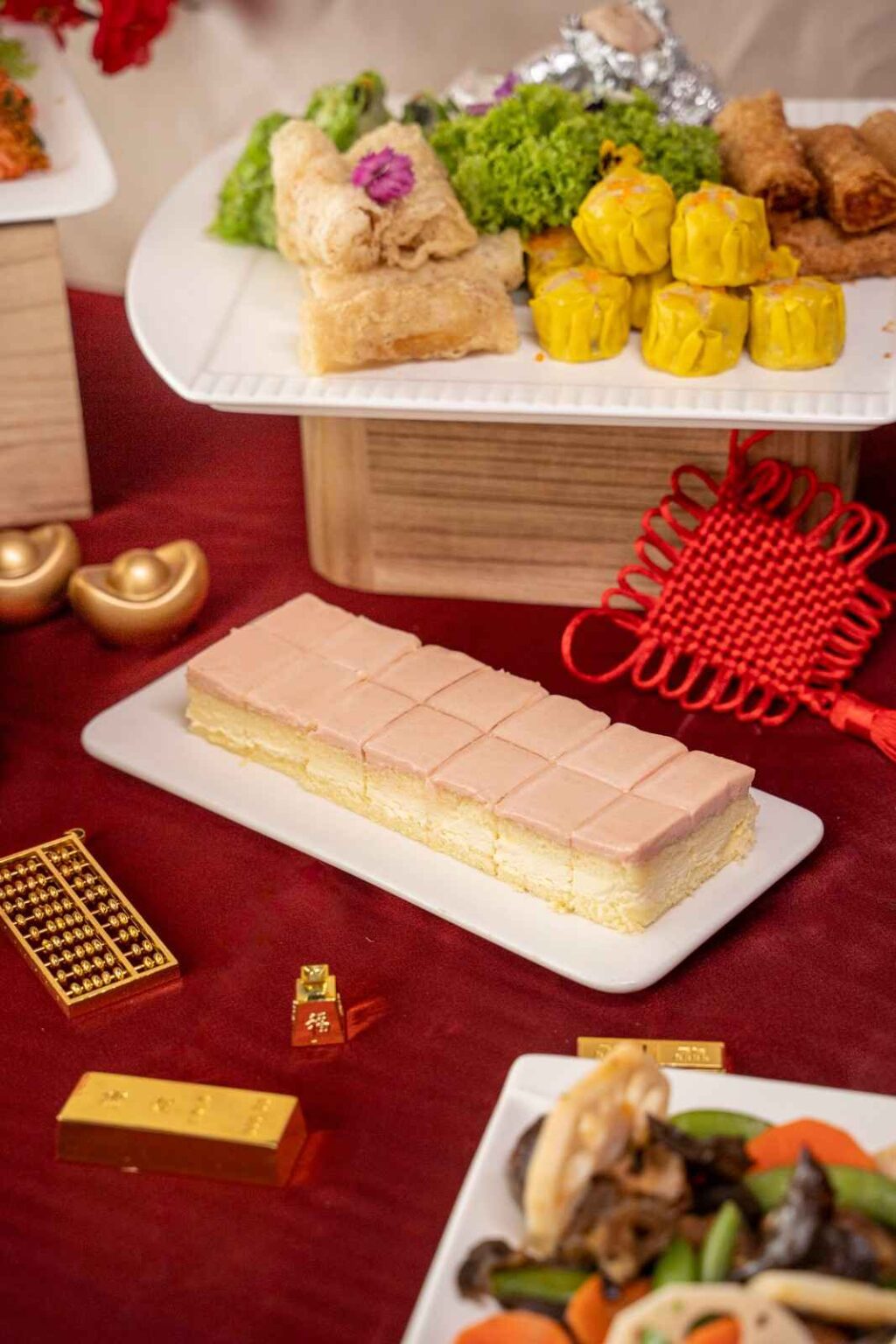 Sliced sponge cake with pink frosting on a long plate, iDoCatering Chinese New Year 2026 catering menu
