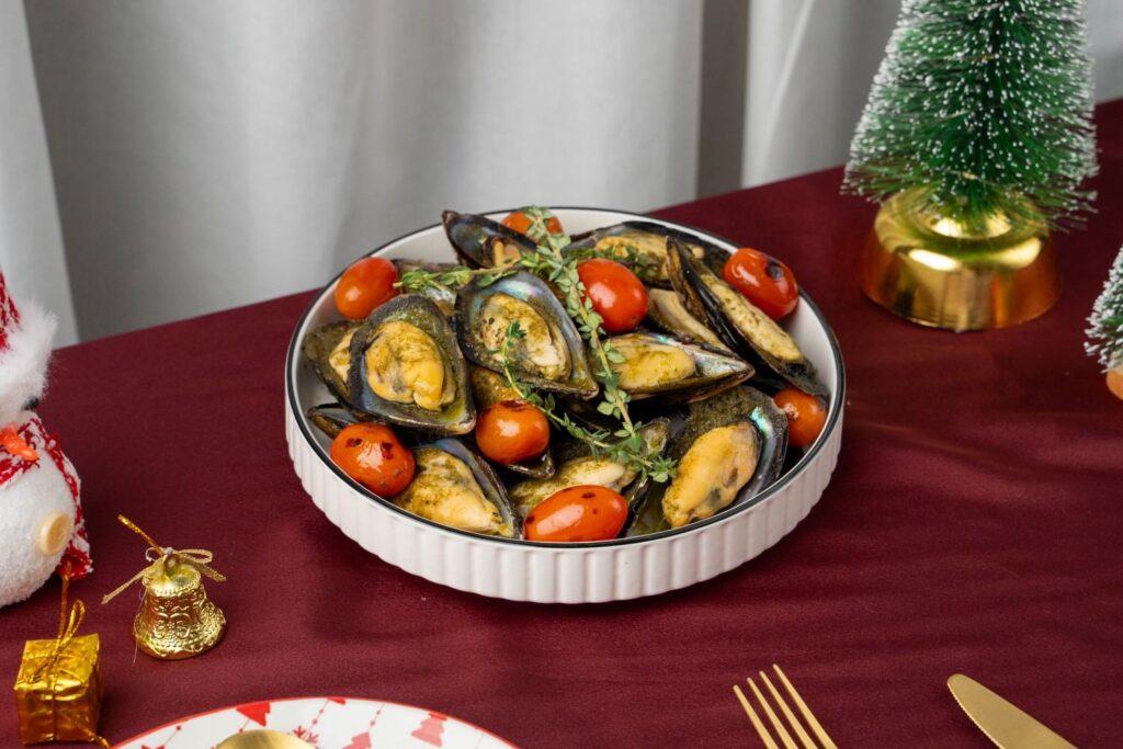 Baked half-shell mussels with cherry tomatoes and thyme, a dish from the iDoCatering Christmas 2025 menu