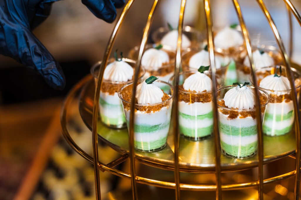 Pandan gula melaka dessert cups in a gold birdcage display at a wedding catered by iDoCatering