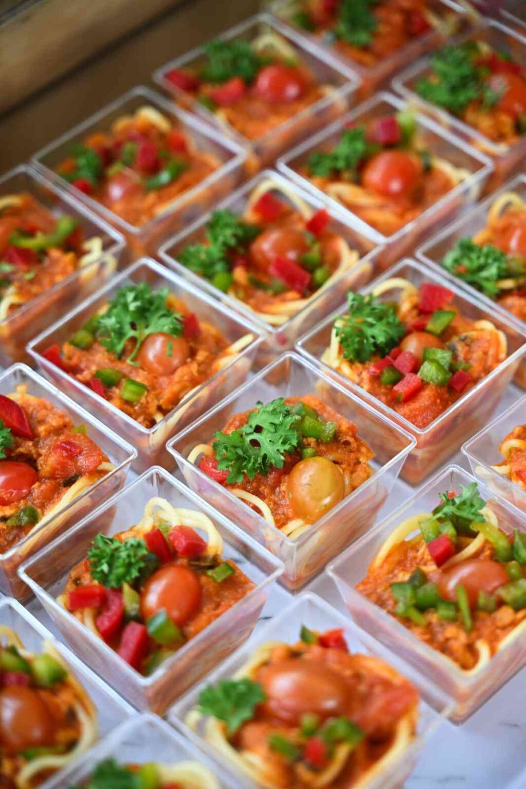 Mini bolognese pasta cups topped with parsley and cherry tomato, iDoCatering canapes at the Eco Marble grand opening
