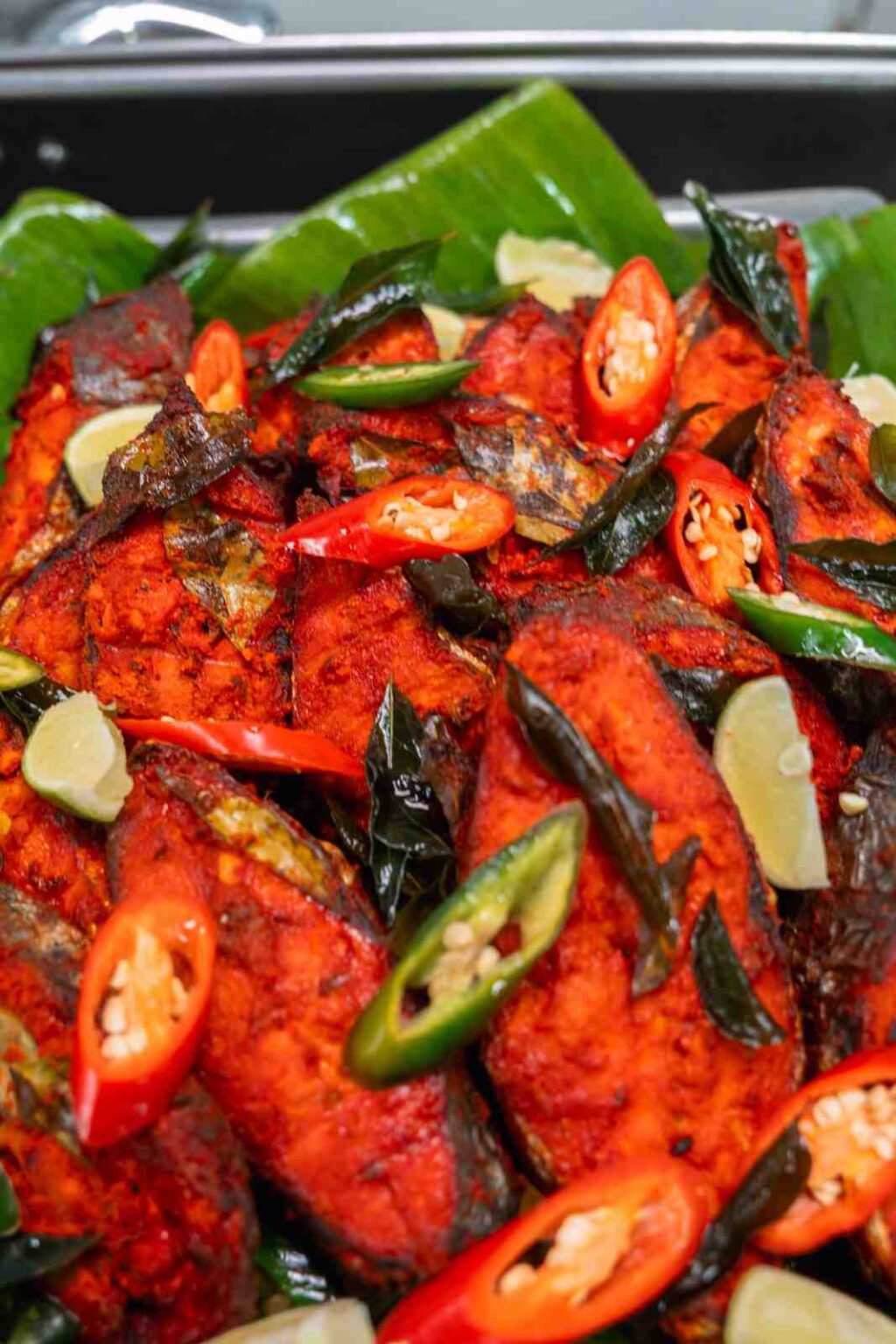 Masala fried fish with curry leaves, lime and chillies on banana leaf, office Deepavali catering 2025