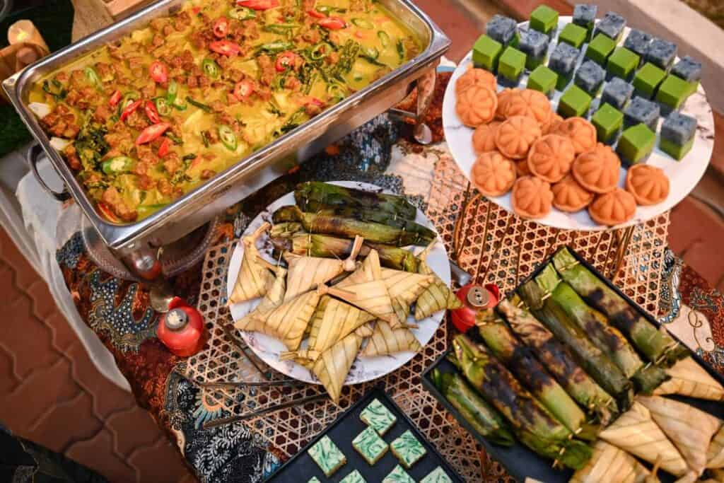 Raya spread with vegetable curry, ketupat palas, grilled otak-otak in banana leaf and nyonya kuih by iDoCatering