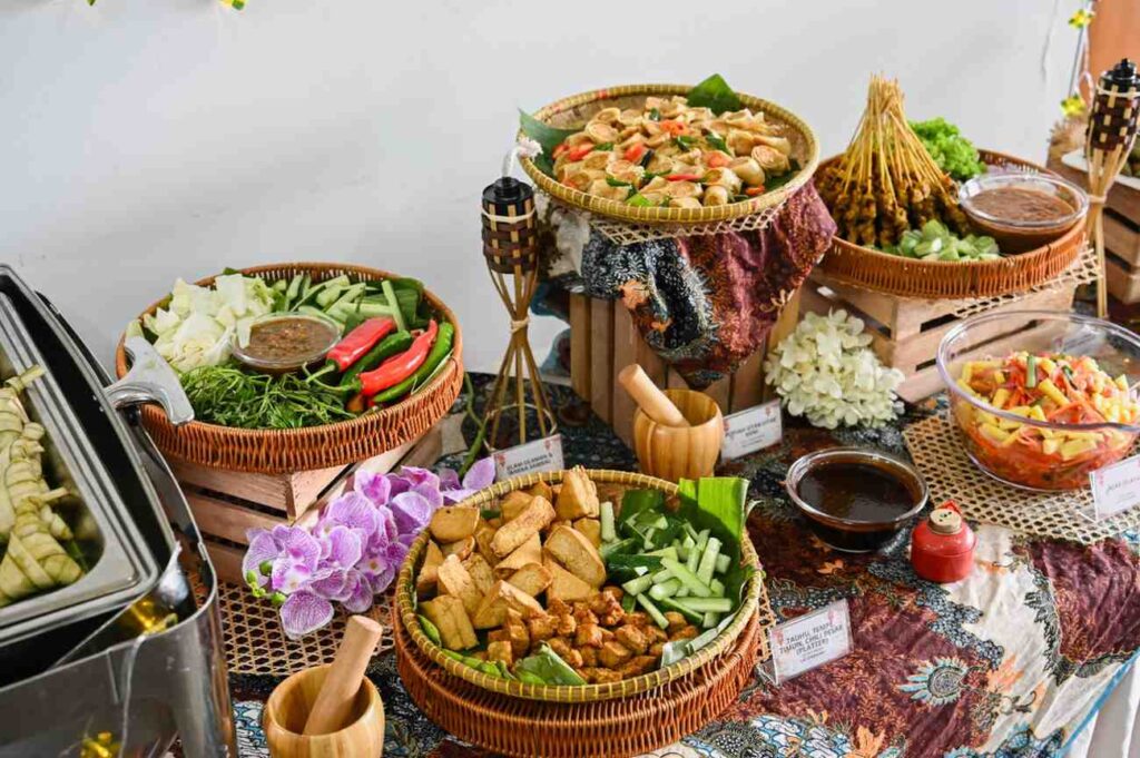 Hari Raya ulam platter with sambal belacan, fried tofu and tempeh, satay and acar in rattan baskets, iDoCatering