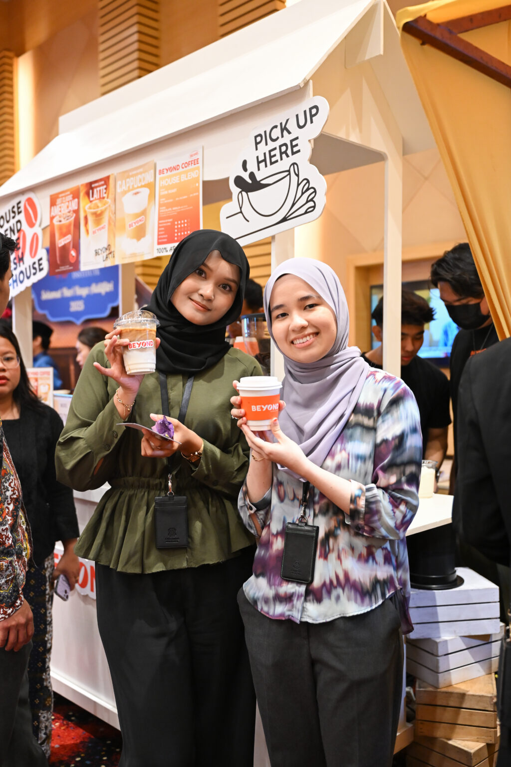 Guests holding iced lattes at a coffee cart booth during a Hari Raya corporate event at Mercu UEM 2025