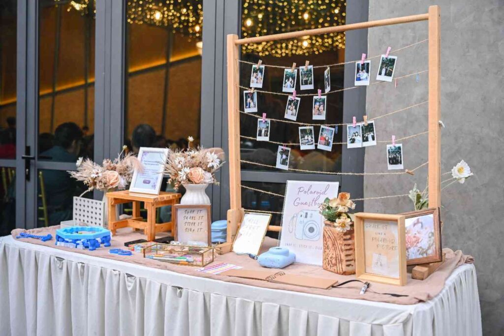 Polaroid guestbook table with hanging photos at a wedding at ROM 8 Studio by Metal Bees, 2025