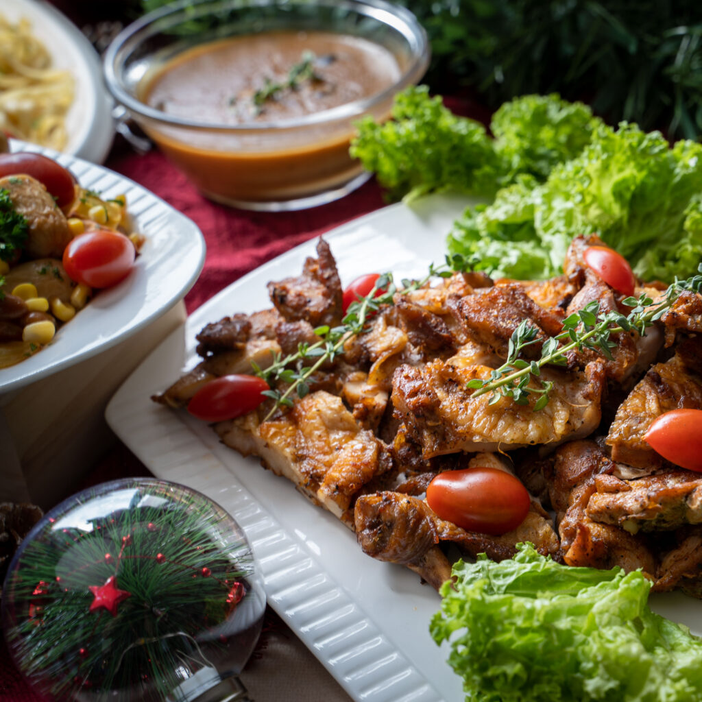 Roast chicken pieces with cherry tomatoes and thyme beside gravy, iDoCatering Christmas 2023 catering
