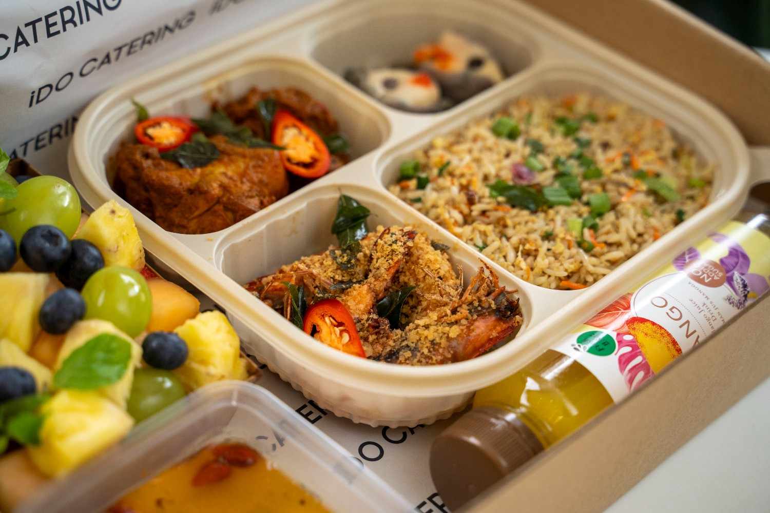 iDoCatering seminar bento with fried rice, chicken curry and cereal prawns beside a fruit cup and mango juice