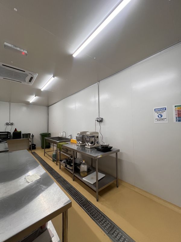 Pastry room at iDoCatering: planetary stand mixer and a countertop oven on stainless benches, with a cream epoxy floor