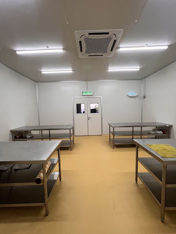 Packing room at iDoCatering with free-standing stainless tables around a tan epoxy floor and double service doors
