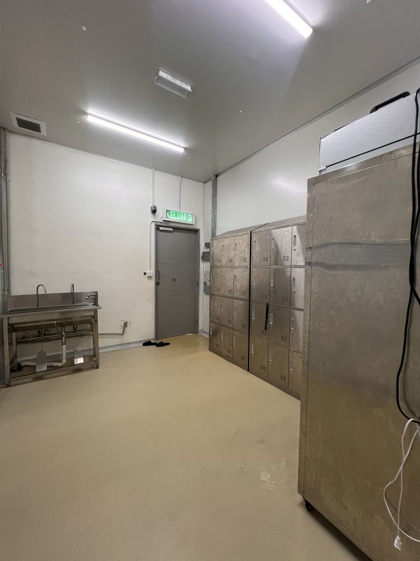 Sanitising room at iDoCatering: stainless storage lockers, a wash station and an upright chiller by the door
