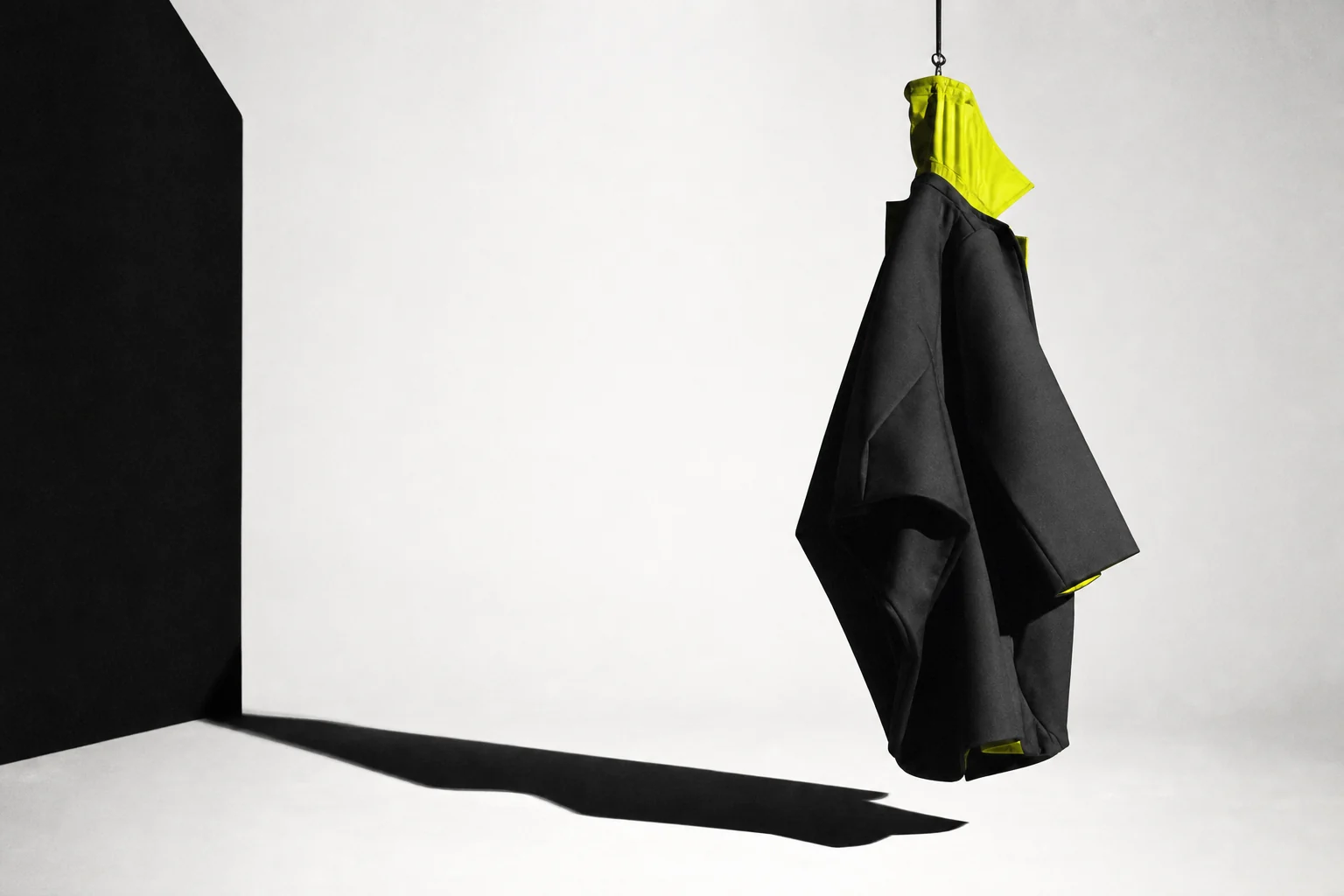 Halde Studio suspended black garment with an acid-lime detail
