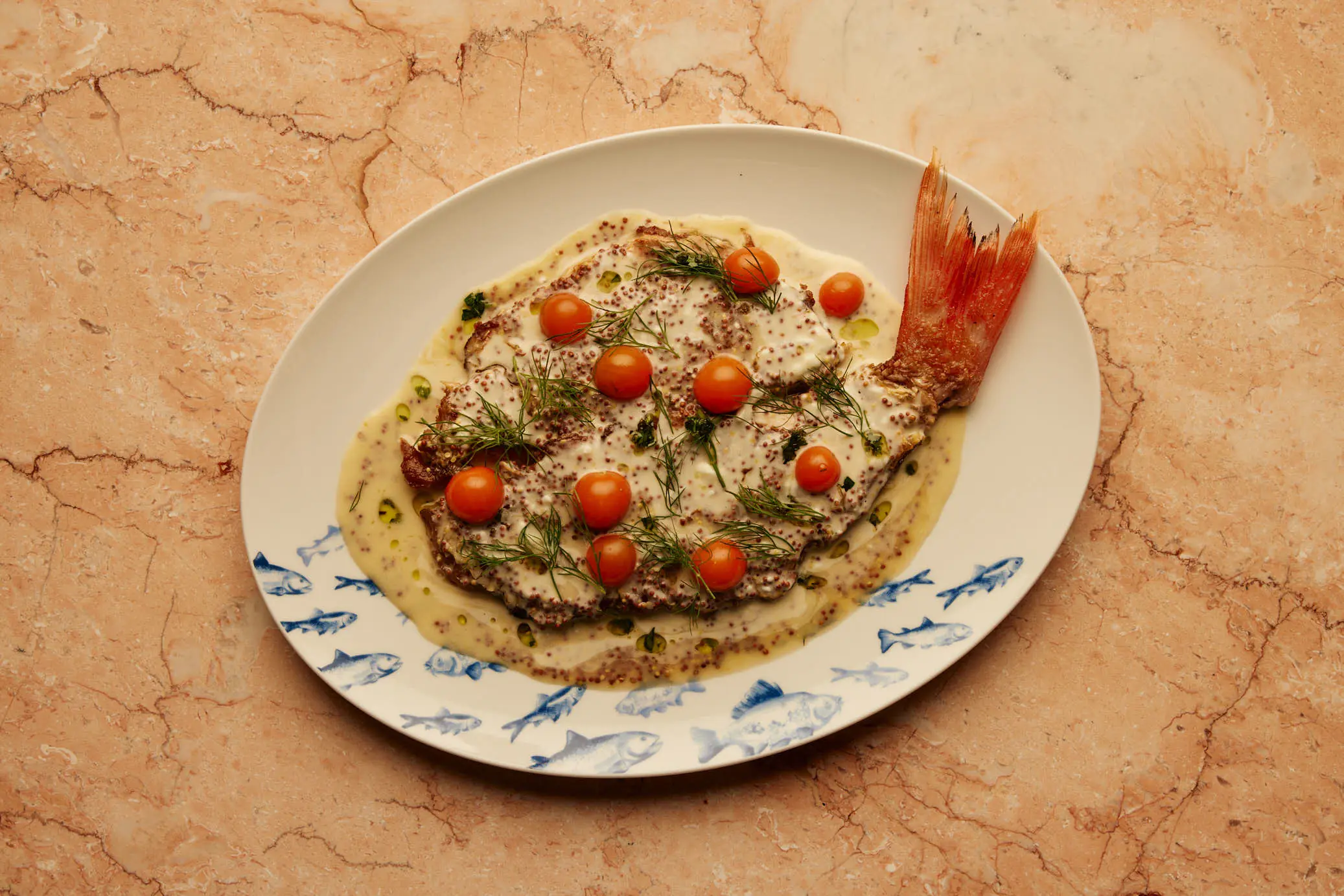 A rice dish with prawn and blistered tomatoes on a painted plate