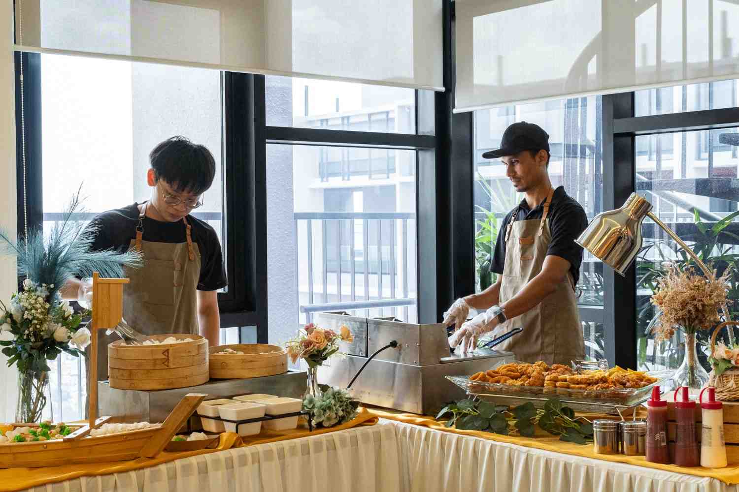 iDoCatering crew running a live station with dim sum steamers and fried snacks at a corporate event in KL