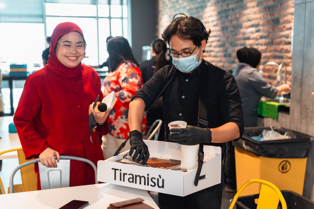 iDo Catering team member serving tiramisu dessert to a PwC Malaysia guest at Lily's farewell corporate event in Kuala Lumpur