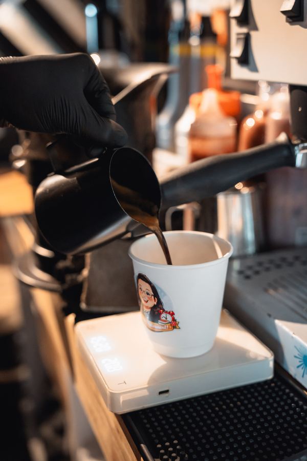 iDo Catering barista pouring espresso into Lily's custom illustrated retirement cup — Beyond Coffee collaboration at PwC farewell KL