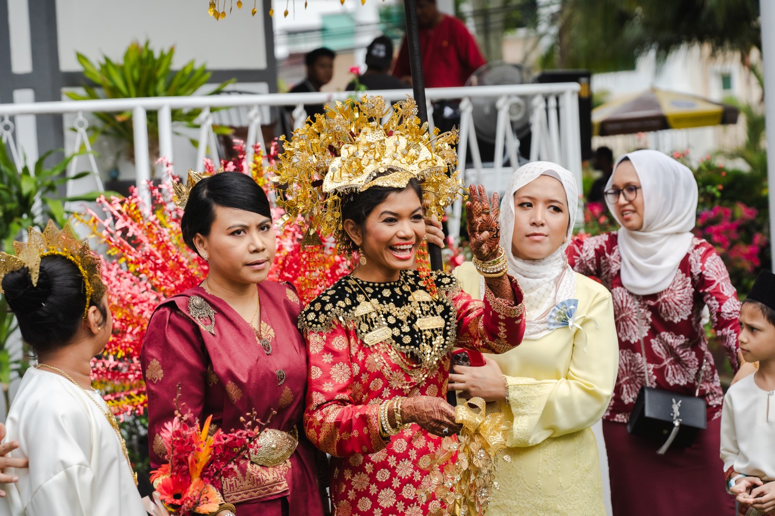 Malay bride in gold headdress and red songket with family at her wedding — iDoCatering wedding catering