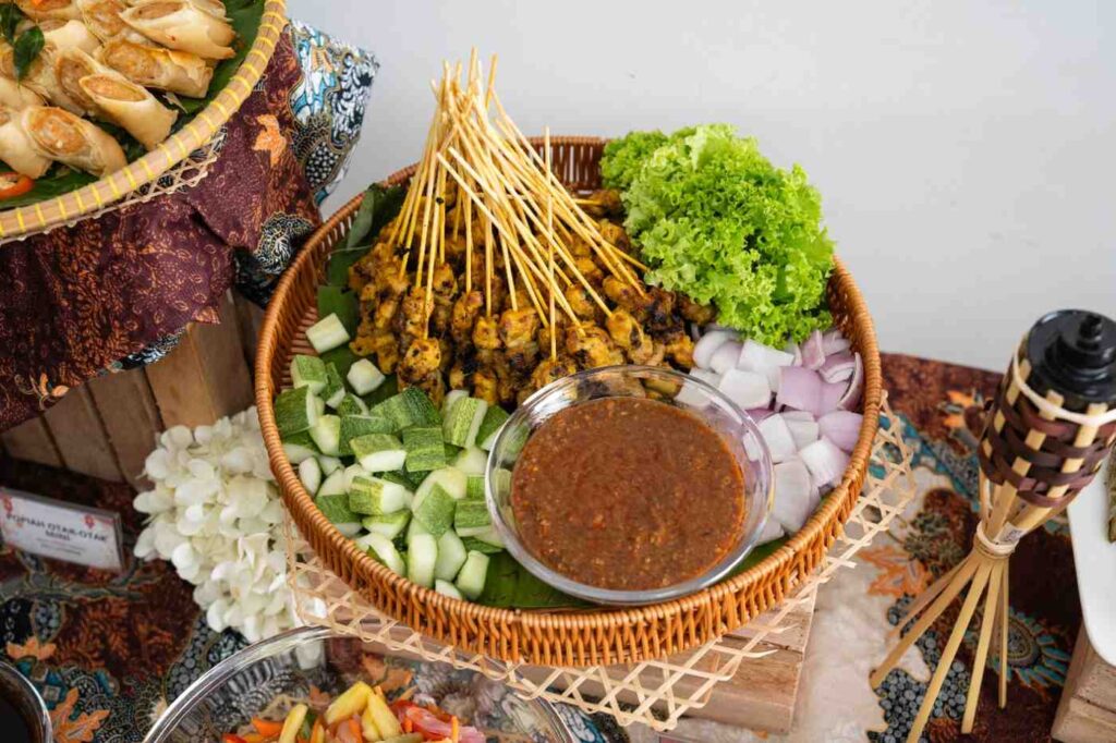Chicken satay with peanut sauce, cucumber and onion in a rattan basket at an iDoCatering Raya buffet