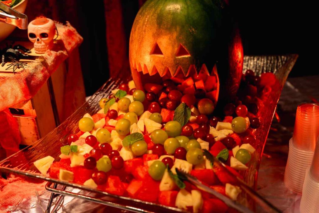 Carved watermelon jack-o'-lantern with fruit salad at the Paxtonz Halloween party at Empire City, by iDoCatering