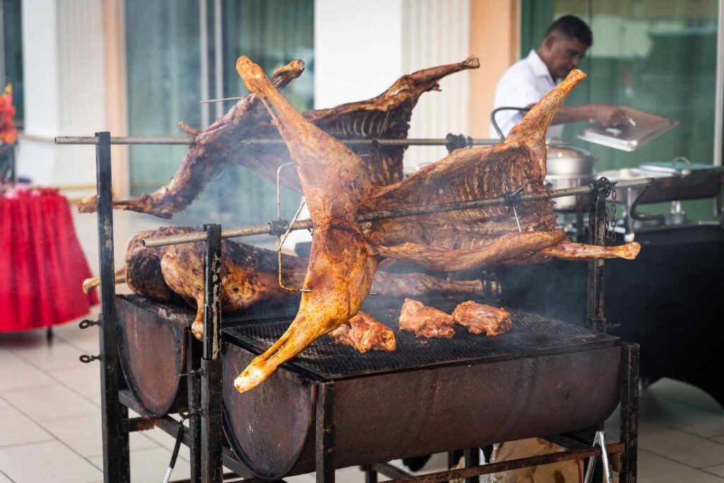 Whole lamb roasting on a spit at an iDoCatering live barbecue station, Seremban wedding